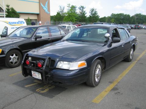 1991 Ford LTD Crown Victoria - dark blue Ford Crown Victoria sedan fitted with a front push bar parked beside another police car.