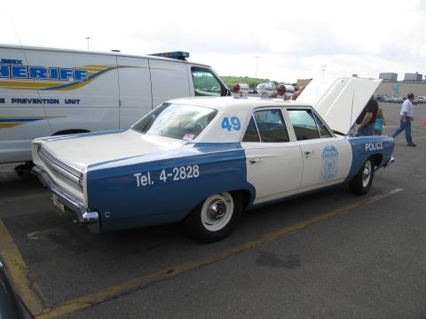 1991 Ford LTD Crown Victoria - blue and white vintage police sedan marked Police with hood open, parked near a Sheriff crime-prevention van.