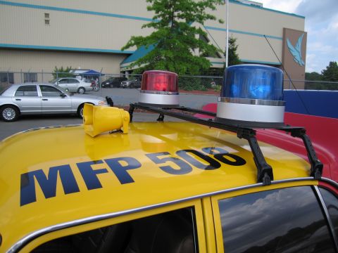 1991 Ford LTD Crown Victoria - Red and blue rotating beacons and a siren mounted on the yellow roof of a car lettered MFP 508.