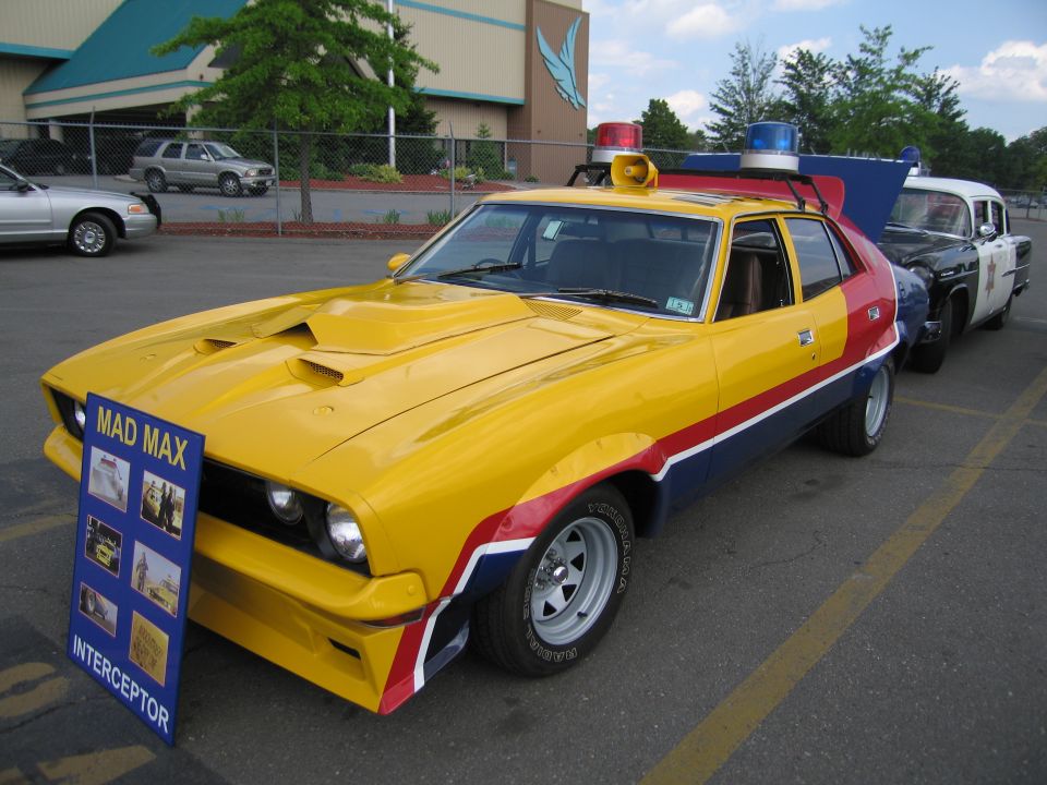 Front of yellow, red and blue Mad Max Interceptor replica at a show