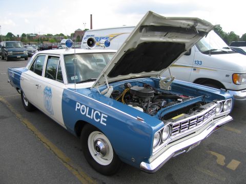 1991 Ford LTD Crown Victoria - Front three-quarter view of a blue and white vintage Police sedan with chrome grille and open hood.