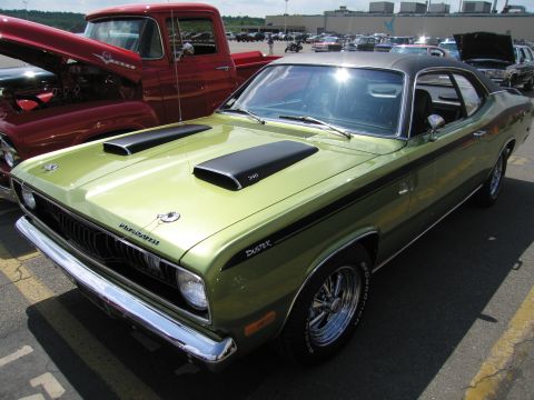 1991 Ford LTD Crown Victoria - green Plymouth Duster 340 muscle car with twin hood scoops and chrome wheels parked at an outdoor car show.