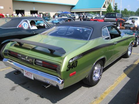 1991 Ford LTD Crown Victoria - green Duster 340 with chrome mag wheels and black stripes is shown from the rear at a car show.