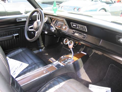 1991 Ford LTD Crown Victoria - black interior of a classic car shows a sport steering wheel, automatic console shifter and wood-grain trim.