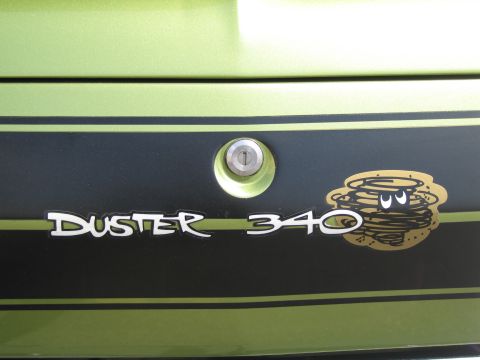 1991 Ford LTD Crown Victoria - Close-up of a black trunk panel reading Duster 340 in white script beside a gold dust-devil cartoon logo.