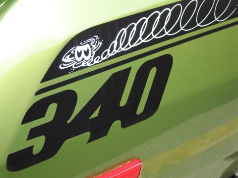 1991 Ford LTD Crown Victoria - close-up shows a large black 340 numeral and a swirling dust-devil cartoon decal on green sheet metal.