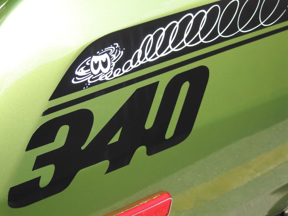 Close-up of black 340 graphic and dust-devil decal on green car body