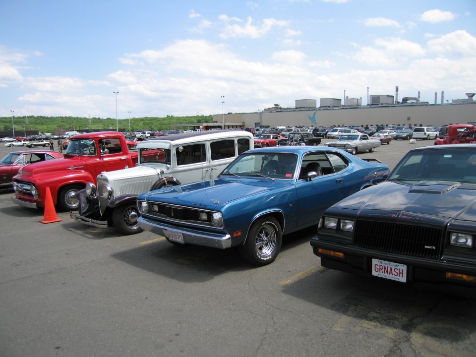 Row of classic cars including blue Plymouth Duster, red truck and Buick
