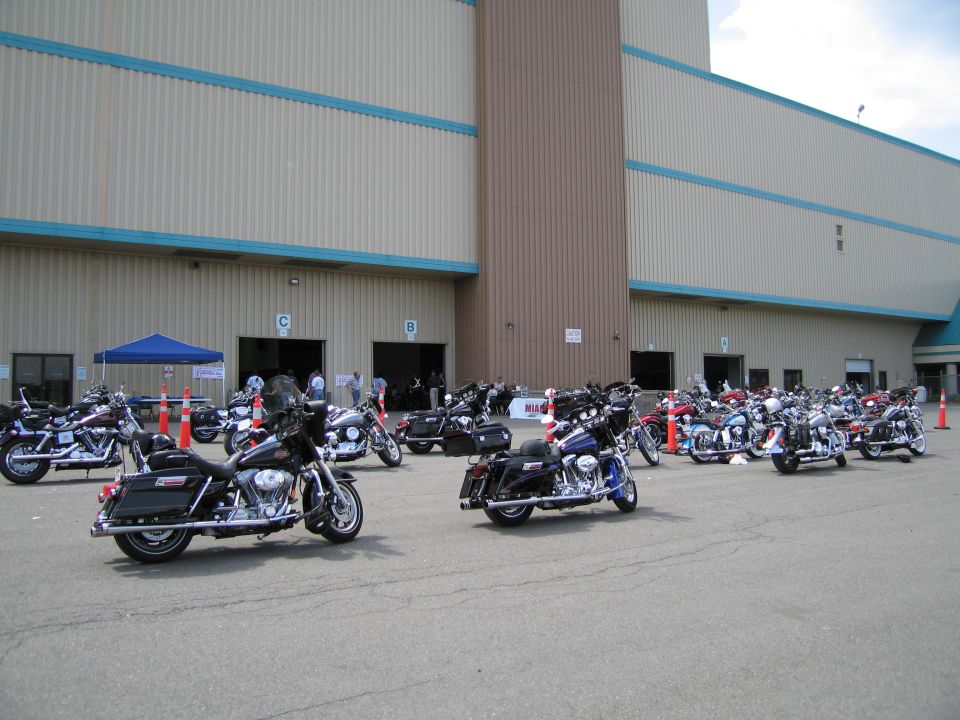 Harley-Davidson motorcycles parked outside a large building at an event