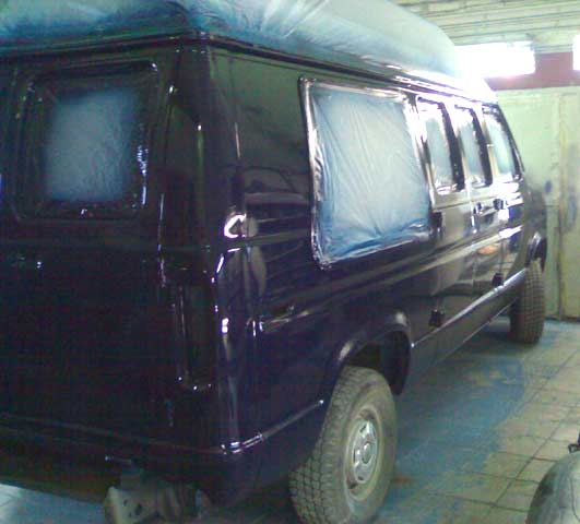 Black painted full-size van in a workshop