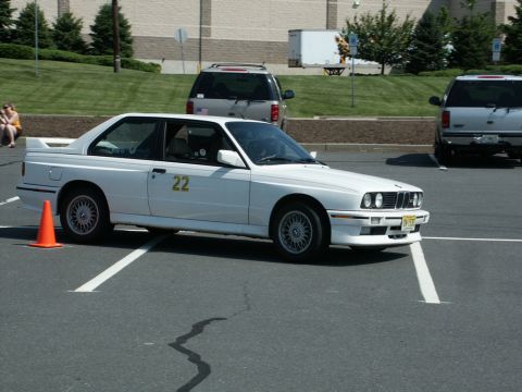 2001 Mercury Grand Marquis - Photograph of a white BMW E30 M3 numbered 22 staged at an autocross event in a parking lot.