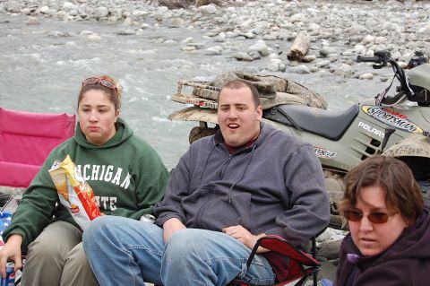 1978 Ford Bronco - An ATV is parked near a river with people sitting in chairs nearby.