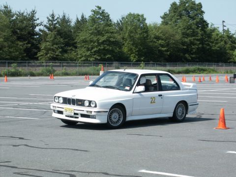 2001 Mercury Grand Marquis - Photograph of a white BMW E30 M3 numbered 22 driving through an orange-coned autocross course.
