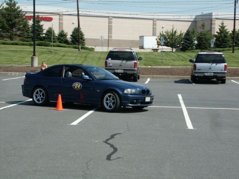2001 Mercury Grand Marquis - Photograph of a dark blue BMW E46 coupe numbered 24 driving an autocross course in a parking lot.