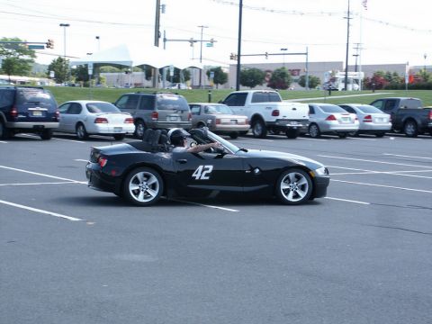 2001 Mercury Grand Marquis - Photo of a black BMW Z4 roadster, number 42, at an autocross in a parking lot with cars and a tent in the background.