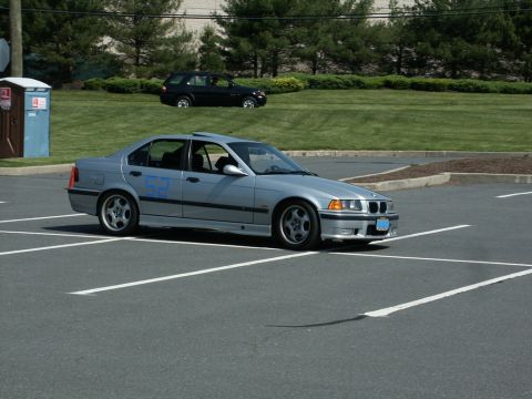 2001 Mercury Grand Marquis - Photo of a silver BMW E36 sedan, number 52, at an autocross event in a parking lot.