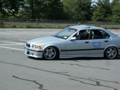 2001 Mercury Grand Marquis - Action photo of a silver BMW E36 sedan, number 52, leaning through a turn at an autocross.