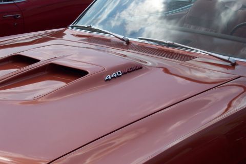 2001 Ford Crown Victoria - The hood of a classic muscle car, painted in a metallic copper color, features dual air scoops and a "440 MAGNUM" emblem. The windshield re…