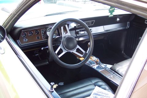 2001 Ford Crown Victoria - The interior of a classic car is shown, featuring a wood-grain dashboard with multiple gauges, a black steering wheel with a chrome horn bu…