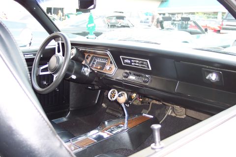 2001 Ford Crown Victoria - The interior of a classic car, showing the dashboard, steering wheel, gear shifter, and gauges. A green pine tree air freshener hangs from…