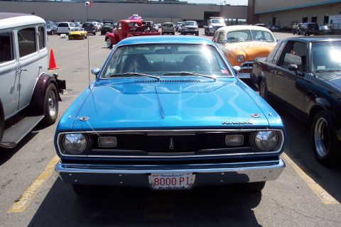 2001 Ford Crown Victoria - A bright blue 1970 Plymouth Duster is parked in a lot with other vehicles, displaying flame decals on its hood and a Massachusetts license…