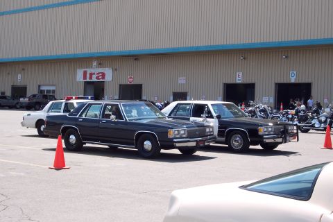 2001 Ford Crown Victoria - Multiple vehicles are parked in a lot, with some orange cones visible.