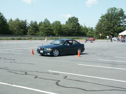 2001 Mercury Grand Marquis - A dark green BMW coupe navigates an autocross course marked by orange cones.