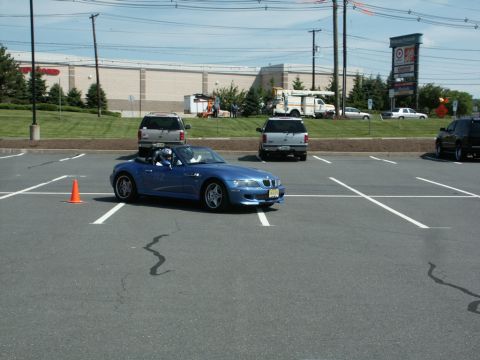 2001 Mercury Grand Marquis - Blue convertible sports car in a parking lot with other vehicles and buildings visible.