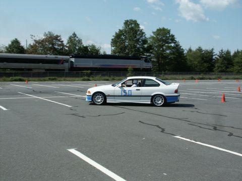 2001 Mercury Grand Marquis - A white BMW E36 coupe participates in an autocross event with a train in the background.