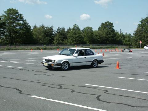 2001 Mercury Grand Marquis - White BMW E30 coupe with racing numbers on door, parked on asphalt course with orange cones.