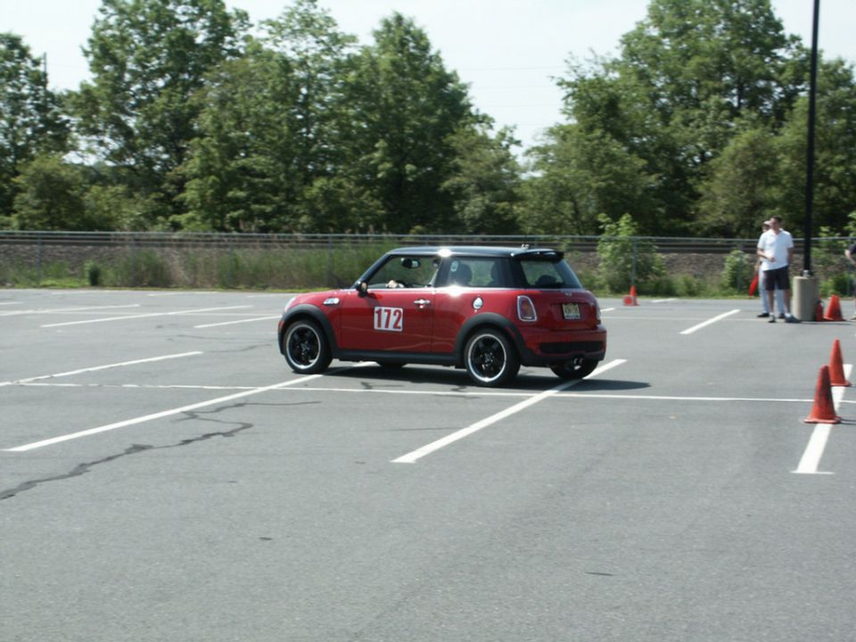 Red Mini Cooper with black roof and racing number 172 on door, seen from a 3/4 front angle