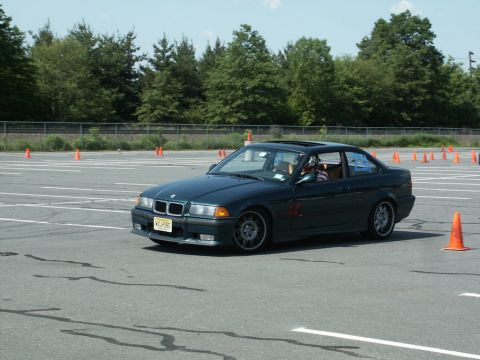 2001 Mercury Grand Marquis - A BMW E36 coupe navigates a course marked by orange cones on a sunny day.