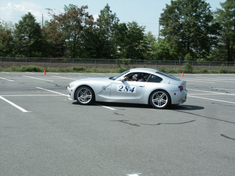 2001 Mercury Grand Marquis - Silver BMW Z4 coupe participating in an autocross event on a paved track.
