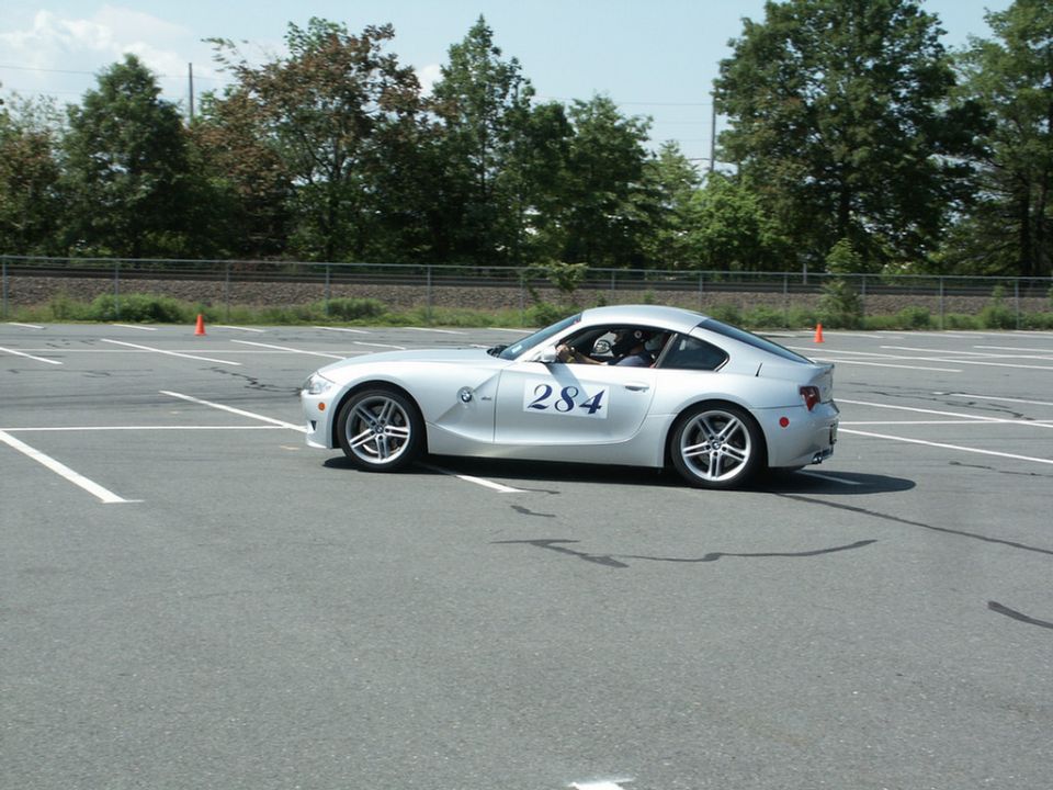 Silver BMW Z4 coupe with number 284 on door, driving on asphalt track