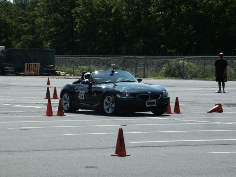2001 Mercury Grand Marquis - A black BMW convertible is driven through an autocross course marked by orange cones.