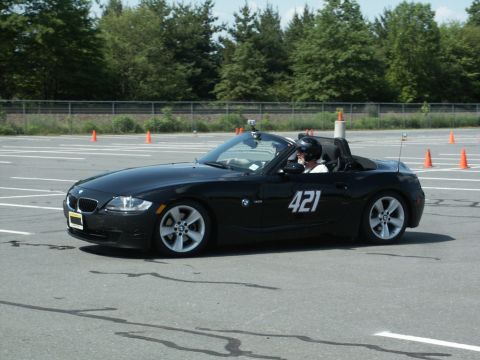 2001 Mercury Grand Marquis - A black convertible sports car with racing number 421 is seen on a track with orange cones.