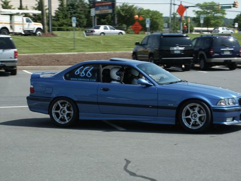 2001 Mercury Grand Marquis - Blue BMW E36 coupe on track with racing numbers and website on the window.