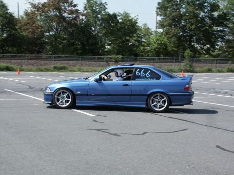 2001 Mercury Grand Marquis - A blue BMW coupe navigates a course, indicated by orange cones and white lane markings.
