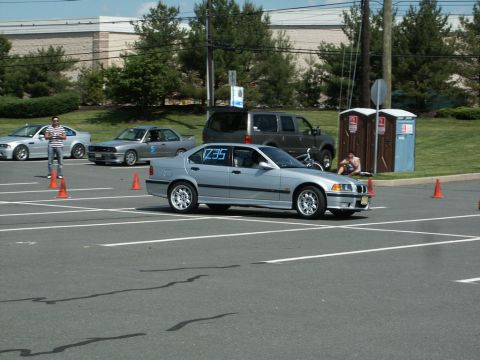 2001 Mercury Grand Marquis - A silver BMW 3 Series sedan is seen on a race track with other vehicles in the background.