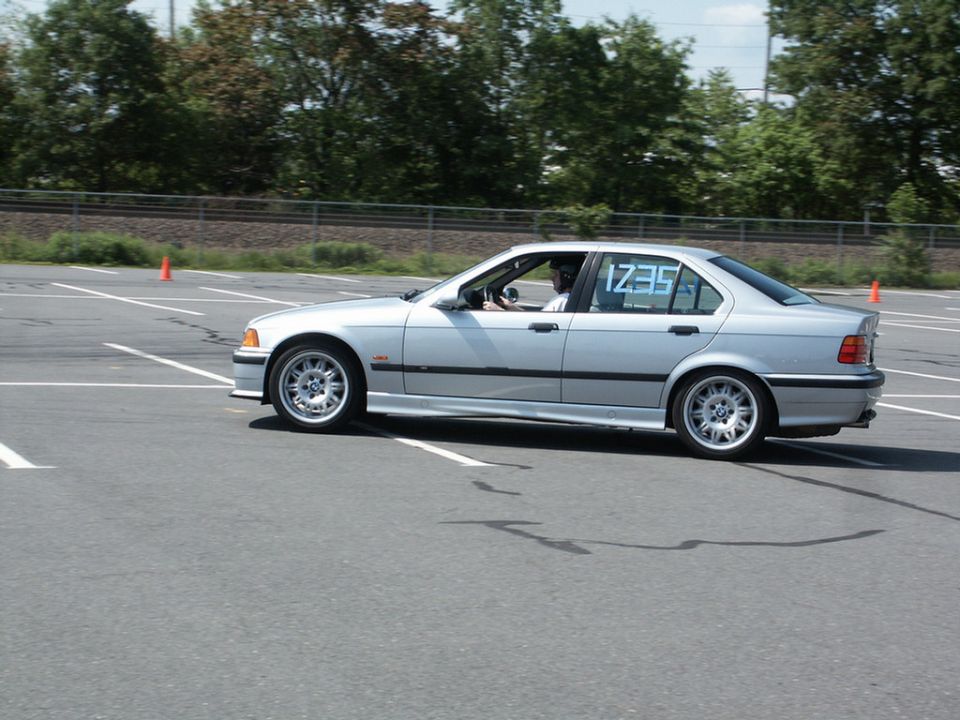 Silver BMW E36 3-Series sedan at an autocross with 1235 written on the rear window