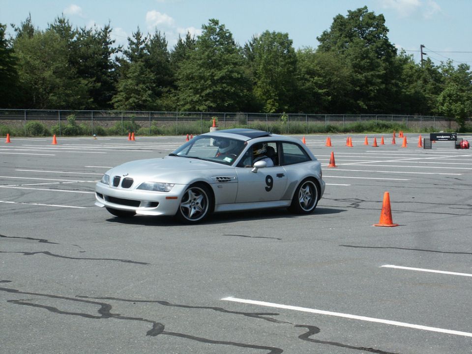 Silver BMW Z3 Coupe with racing number 9 on the side, driving on a paved course with orange cones