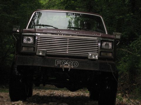 1980 Ford Bronco - This Ford F-Series truck is parked on a gravel path surrounded by trees.