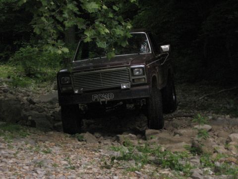 1980 Ford Bronco - 1980 Ford Bronco navigating a rocky off-road path.