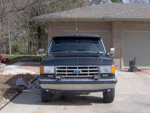 1987 Ford Bronco - This 1987 Ford Bronco is shown from the front, parked in front of a garage with the doors closed.