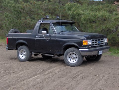 1987 Ford Bronco - This 1987 Ford Bronco is shown from a three-quarter front angle on a dirt surface.