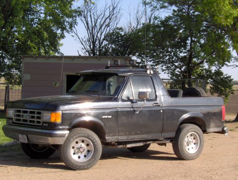 1987 Ford Bronco - This 1987 Ford Bronco is parked on a dirt road in front of a shed.
