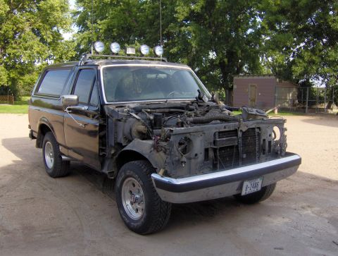 1987 Ford Bronco - This 1987 Ford Bronco shows significant damage to its front end, including the grille and headlights, and is equipped with a roof rack mult…