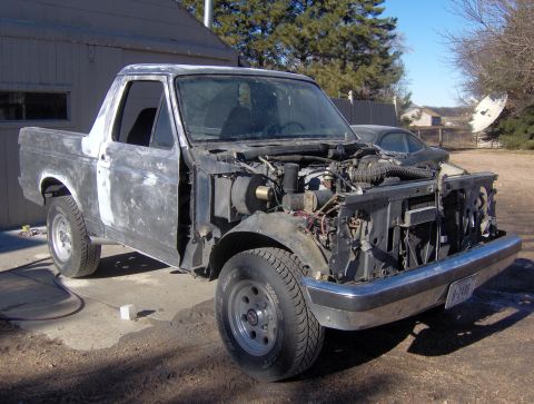 1987 Ford Bronco - This 1987 Ford Bronco is undergoing restoration, with its hood open revealing the engine bay.