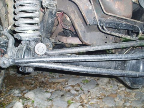 1980 Ford Bronco - A close-up view of the undercarriage of a vehicle, showing the suspension components, differential, and exhaust system. The vehicle appears…