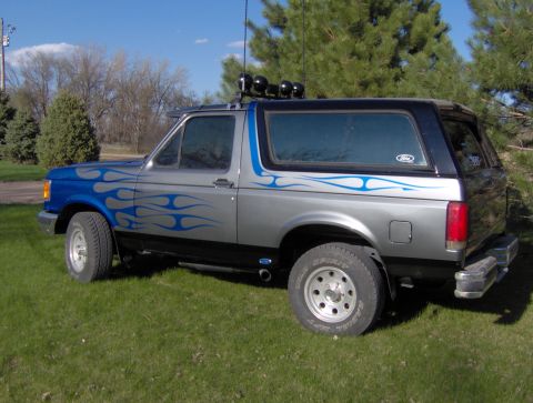 1987 Ford Bronco - 1987 Ford Bronco with custom flame decals and roof-mounted lights.